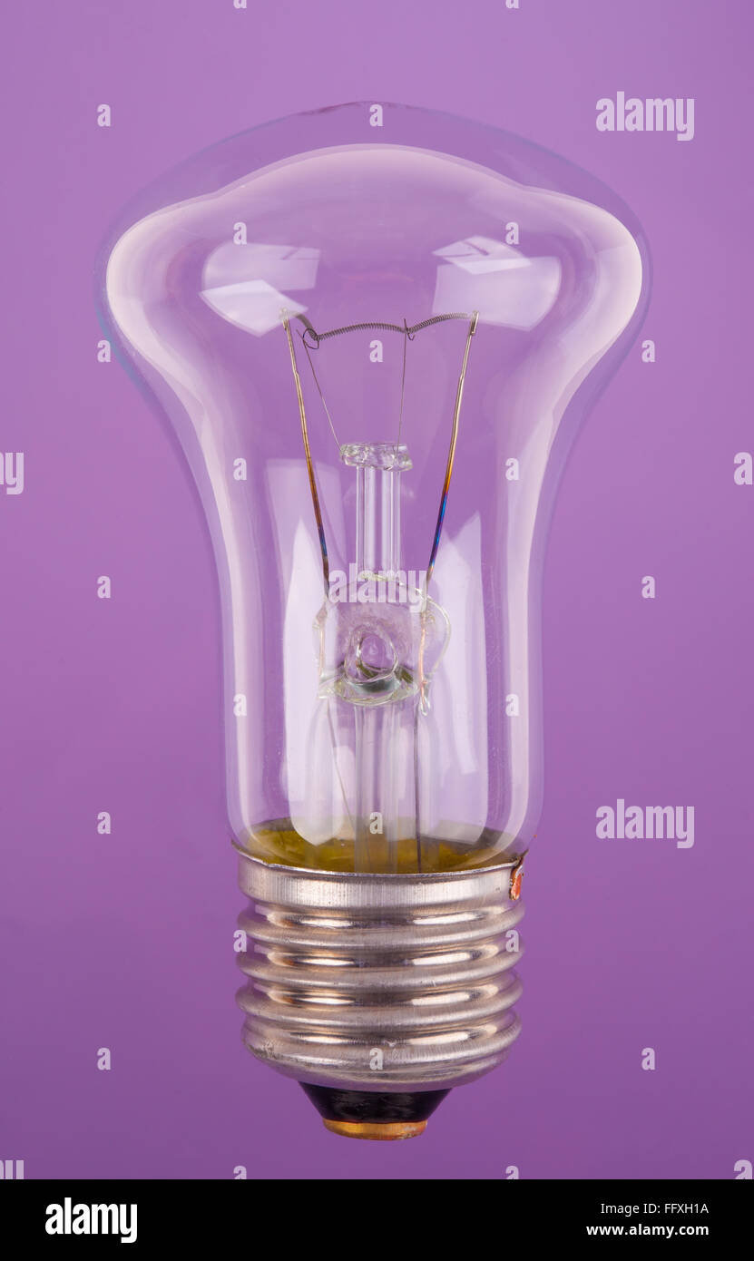 traditional incandescent light bulb on blue purple background Stock Photo