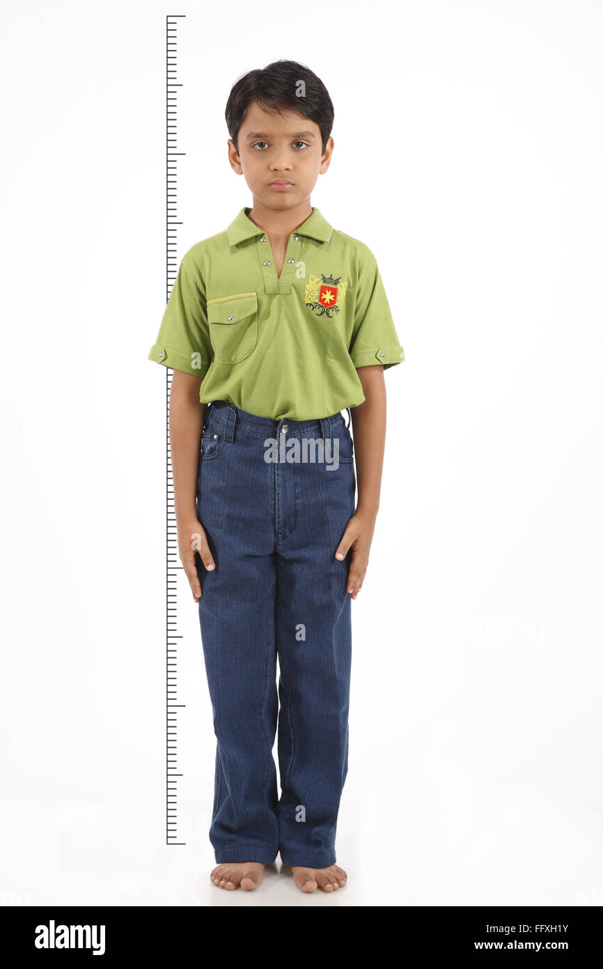 Ten year old boy holding his hand above his head to check his height MR