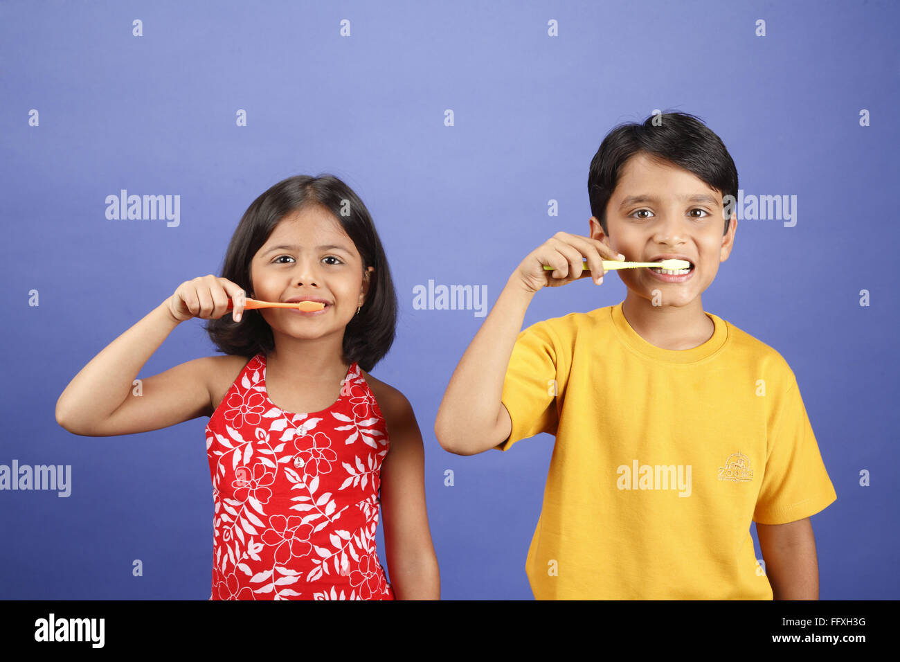 Ten and eight year old boy and girl brushing teeth with tooth brush MR