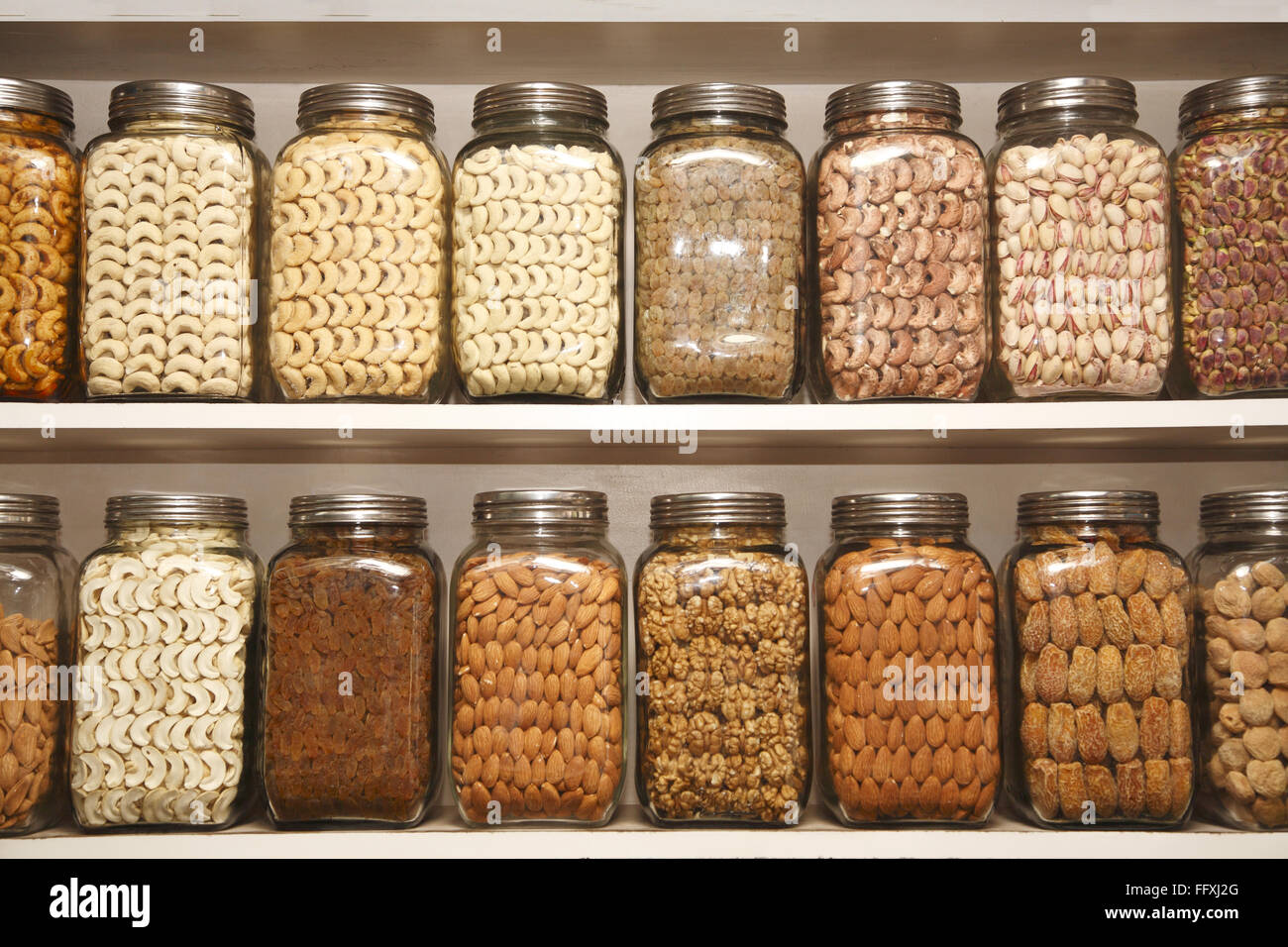 Dry fruits kept in different glass jars on selves in shop Stock Photo