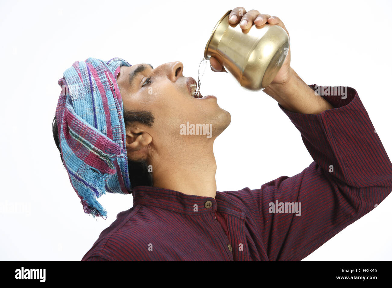Rich Indian farmer drinking water from copper pot vessel holding it