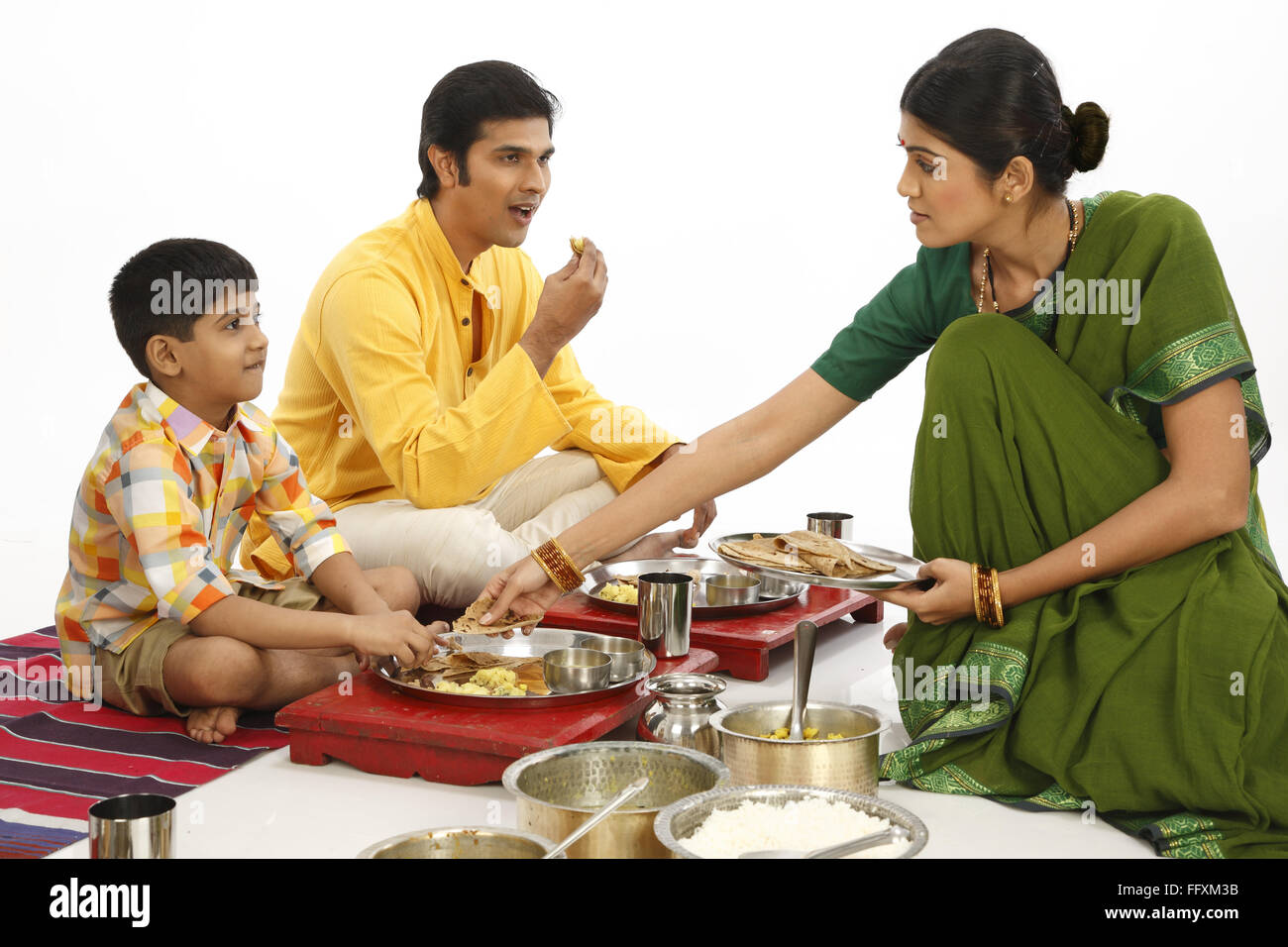 Father eating food and mother serving roti to son MR#743A,743B,743C,743D Stock Photo