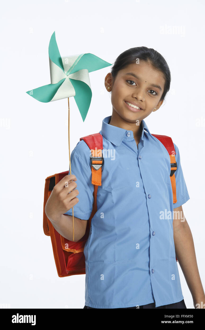 Rural girl carrying school bag on shoulder holding whirligig in left hands MR#743C Stock Photo