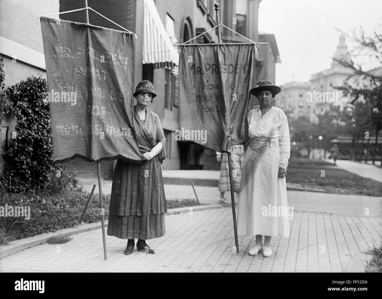 SUFFRAGETTES WITH BANNERS. /nTwo suffragettes in Washington, D.C., with banners reading 'Mr. President what will you do for women's suffrage?' and 'Mr. President how long must we wait for life?' Photograph, 1918. Stock Photo