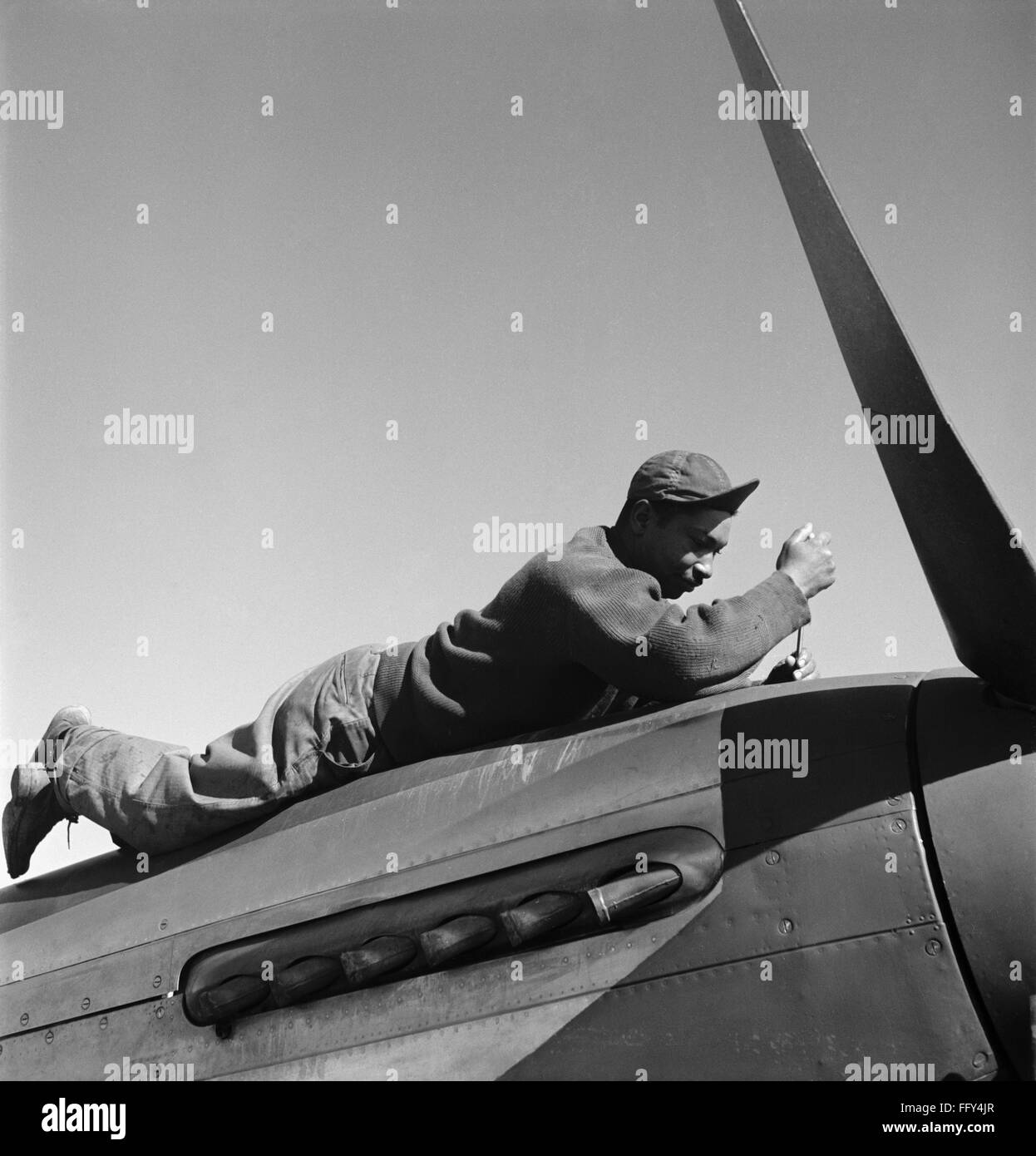 TUSKEGEE AIRMAN, 1945. /nCrew chief Marcellus Smith of the Tuskegee Airmen 100th Fighting Squadron, working on an airplane at Ramitelli Airfield in Italy. Photograph by Toni Frissell, March 1945. Stock Photo