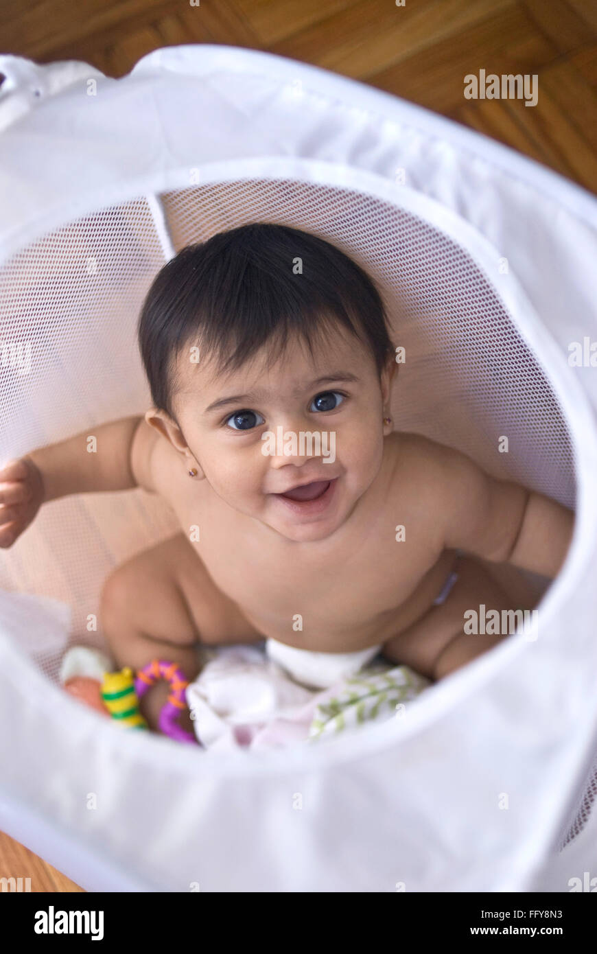 Nine months old bay sitting in laundry basket MR#737 Stock Photo
