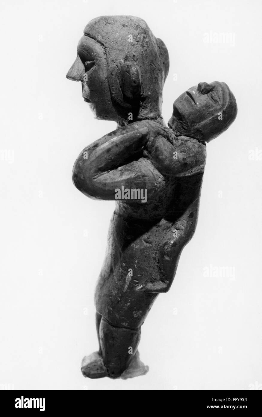 HOPEWELL FIGURINE. /nWooden figure of a mother carrying a child, from