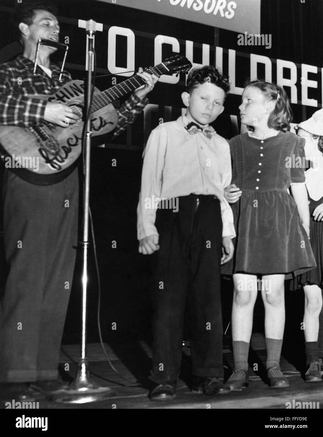 WOODY GUTHRIE (19121967). /nAmerican folk singer, leading children in