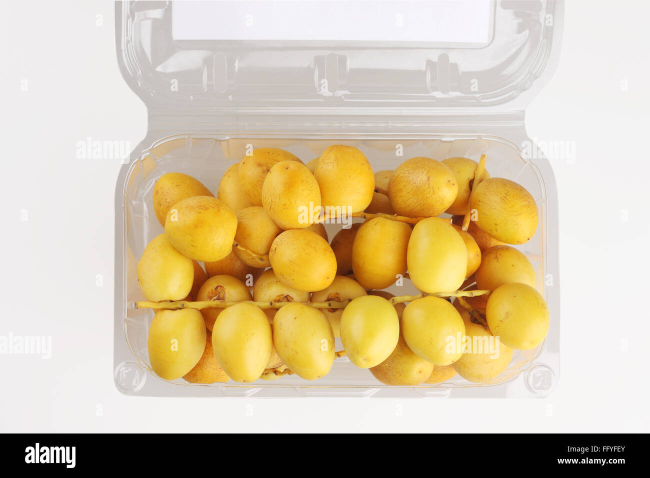 Bunch of yellow dates in plastic box phoenix dactylifera ; India Stock Photo
