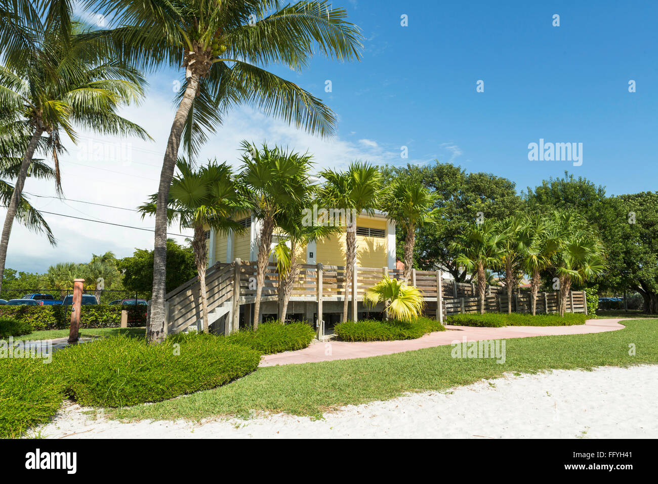 Yellow wooden house on the beach volleyball, sunny day with palm trees