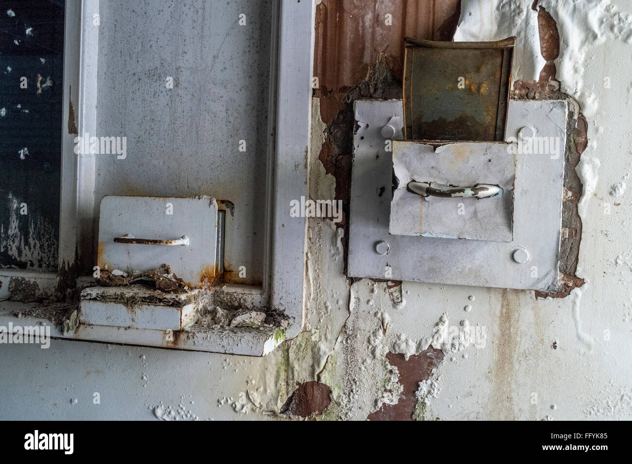 Old and broken pull out wall safe built into a wall which has been vandalized Stock Photo