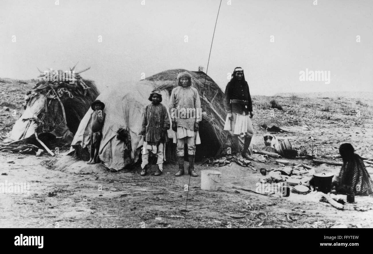 APACHE CAMP, 1882. /nApache Native Americans in camp, one (right) wearing a partial military uniform, in the Arizona Territory. Photographed by A. Frank Randall, 1882. Stock Photo