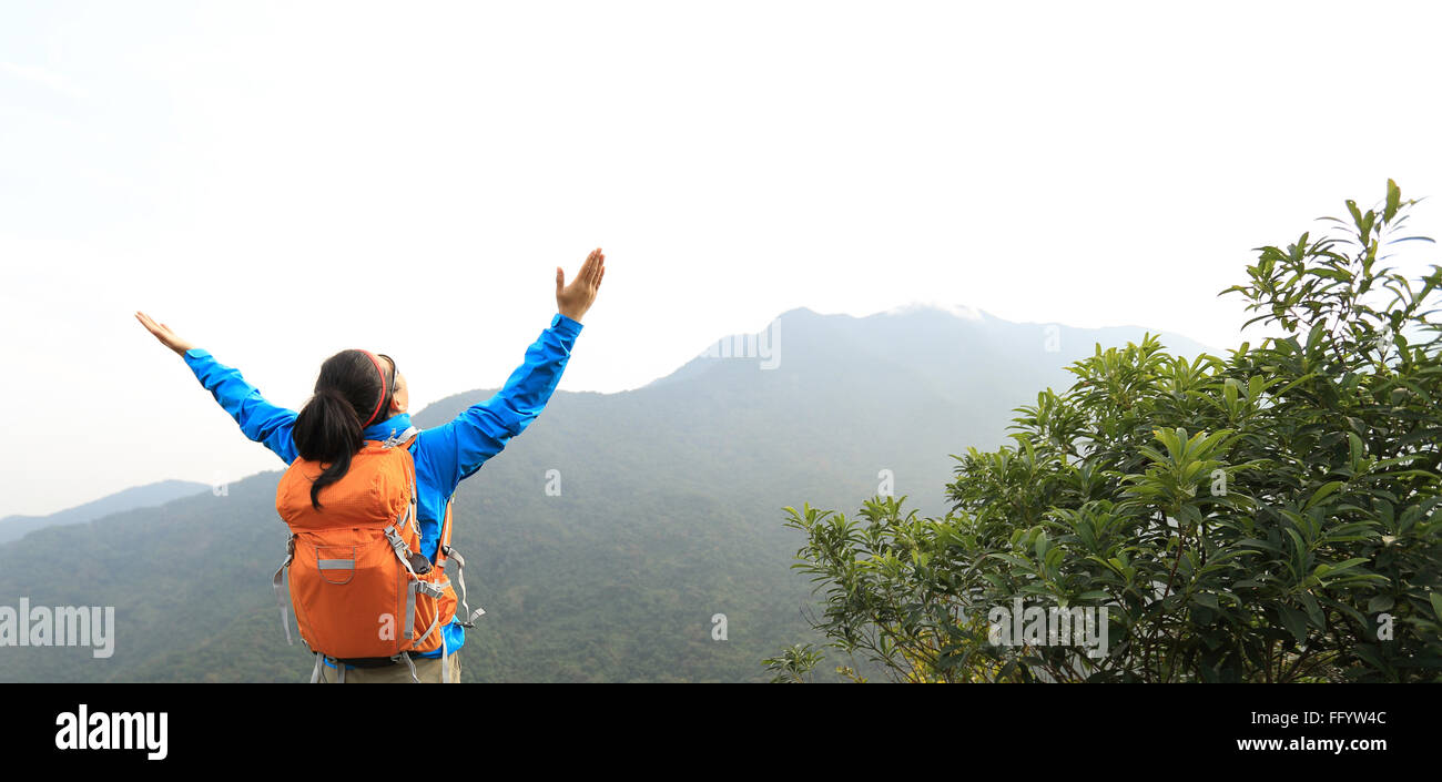 cheering young woman hiker open arms on mountain peak Stock Photo - Alamy