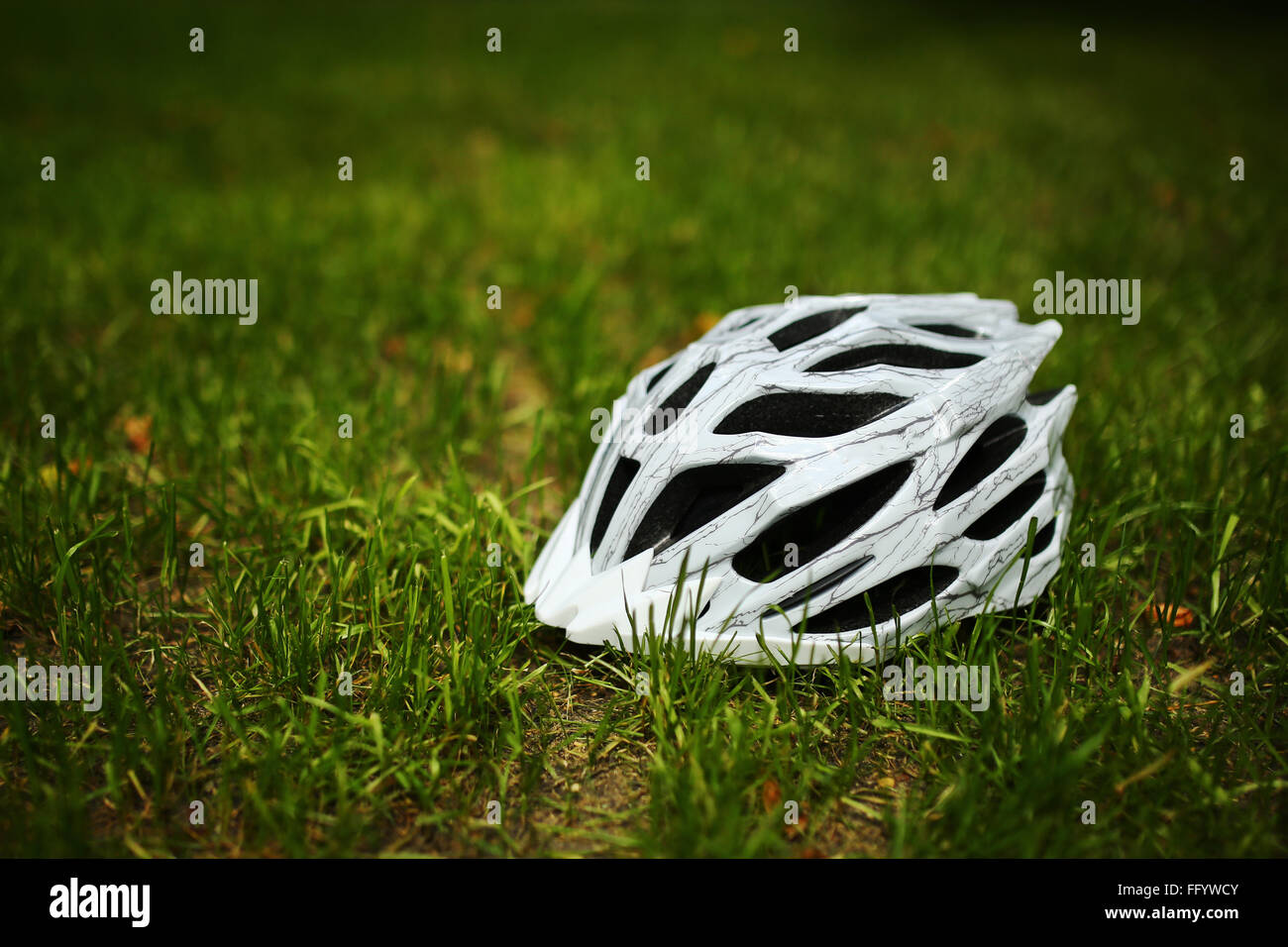 Bicycle helmet on grass Stock Photo - Alamy