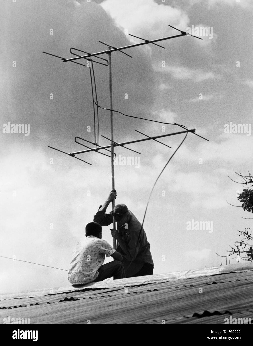 COLOMBIA: TV ANTENNA. /nAn American Peace Corps volunteer installing a ...