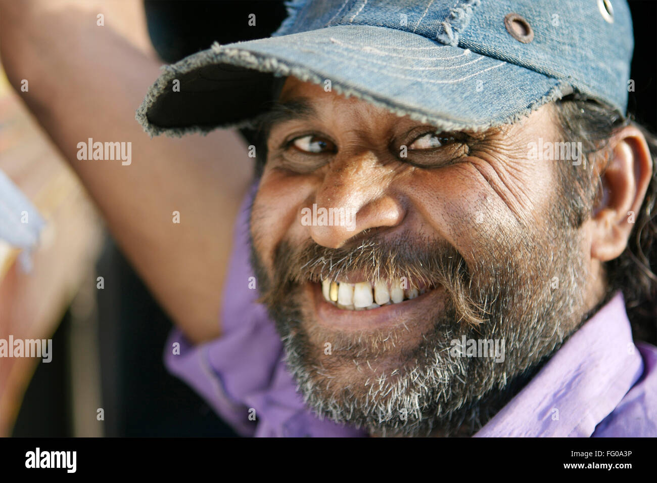 Gujarati man smiling wearing cap showing gold cap teeth sporting beard MR#711 Stock Photo
