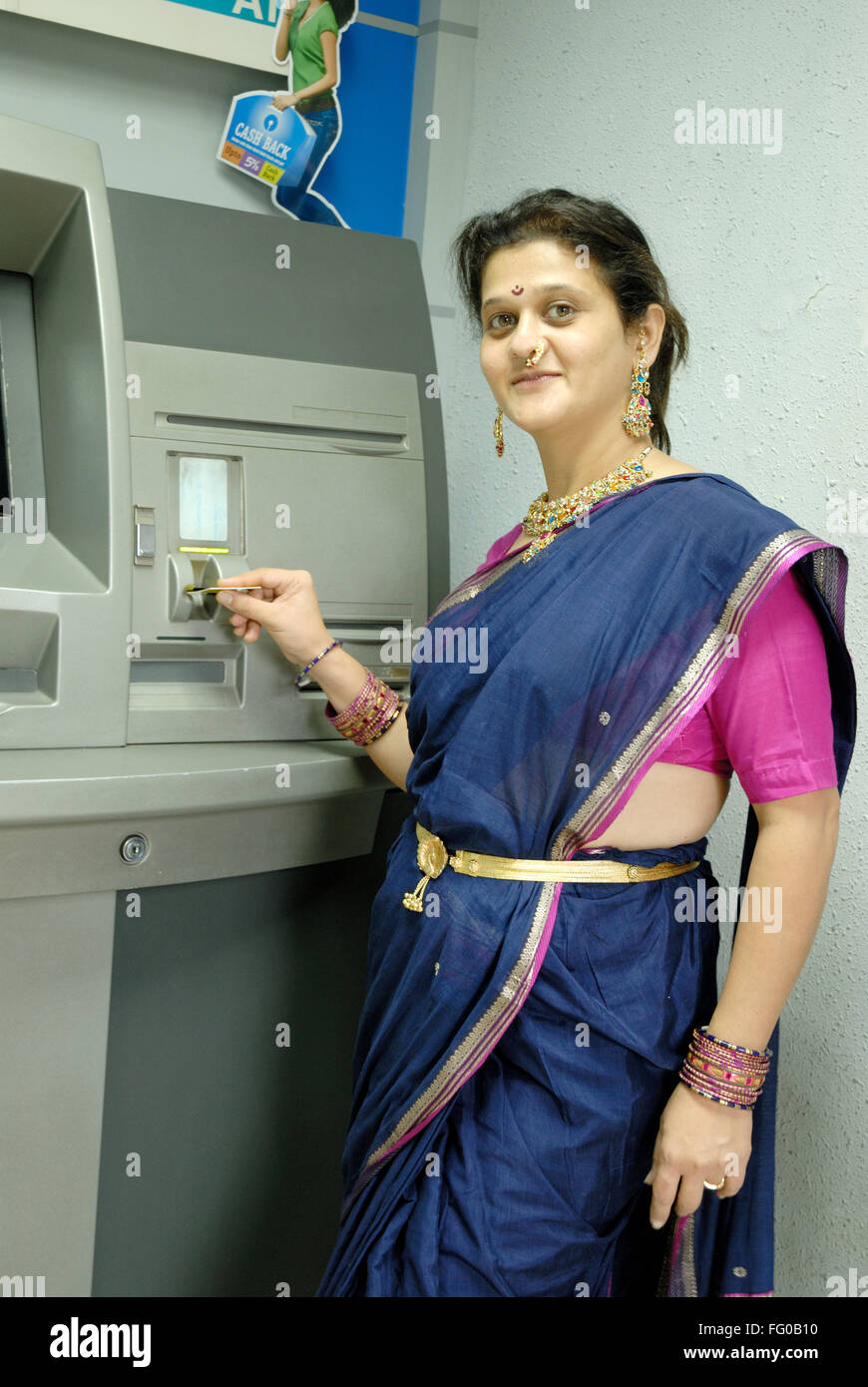 Lady using ATM card for withdraw cash from savings account at Maim , Bombay Mumbai , Maharashtra , India MR#721S Stock Photo