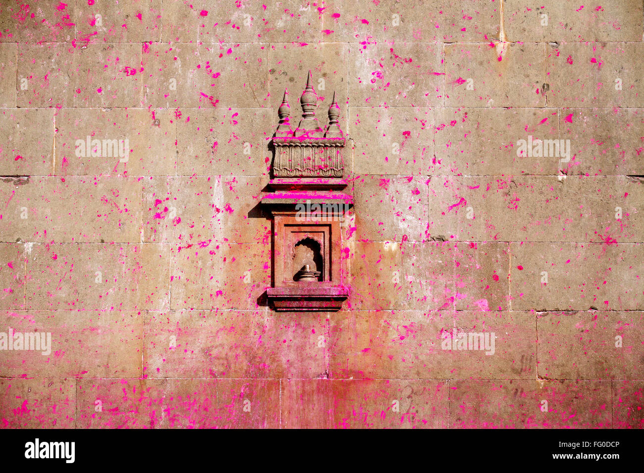 Art work on wall of Jotiba temple immersed in gulal bright shades of pink powder Kolhapur Village Wadi Ratnagiri Maharashtra Stock Photo