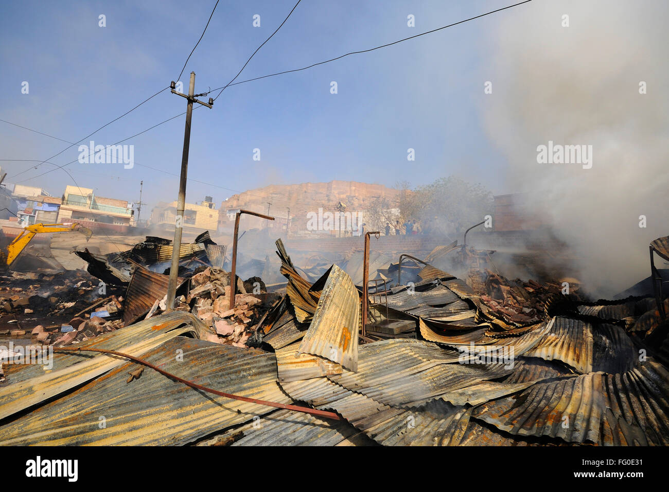 Jcb operator demolish shops while summer market anaaj mandi on fire ; Jodhpur ; Rajasthan ; India Stock Photo