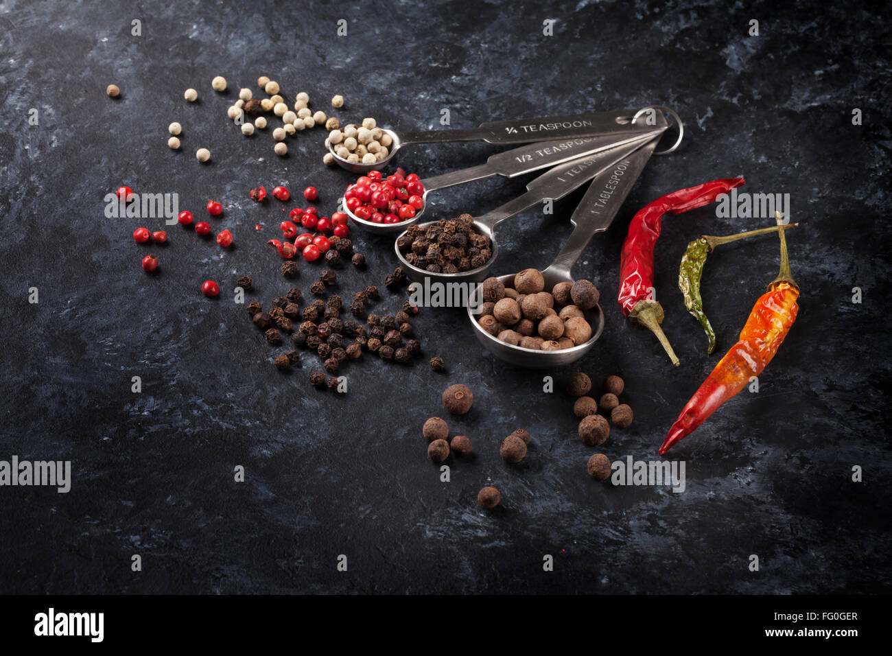 Various peppercorn and chili pepper on black stone table Stock Photo Alamy