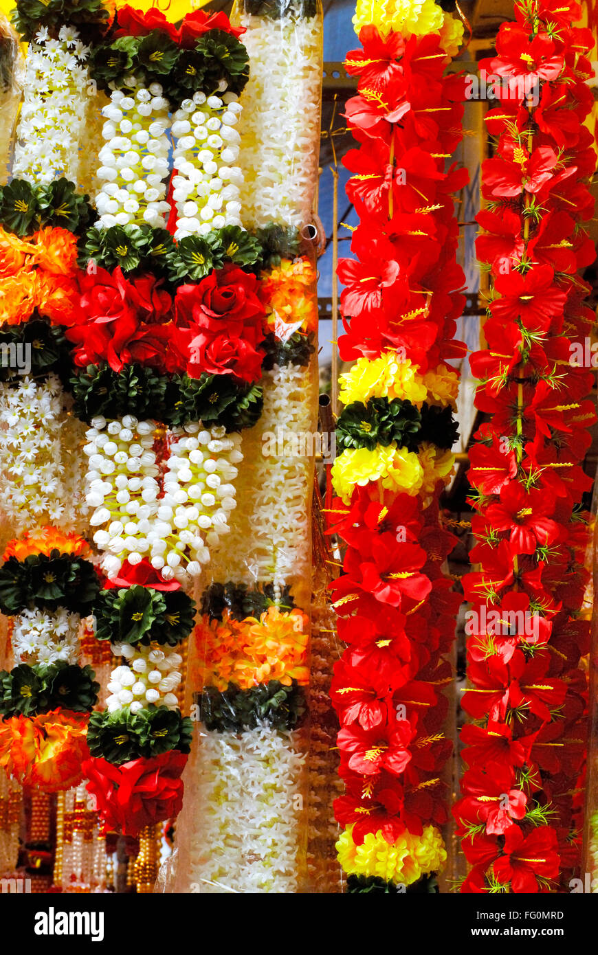 Colourful garlands of artificial flowers hang for sale used to ...