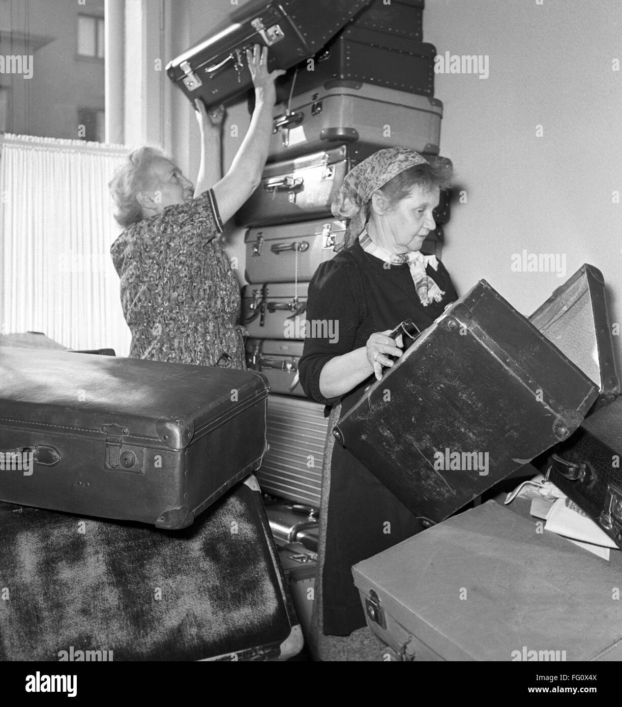 German Red Cross workers in Frankfurt in November 1956 with donated suitcases for hungarian refugees. Due to the put down of the Hungarian Uprising in 1956 by Soviet forces around 200.000 people fled the county towards the West. Stock Photo