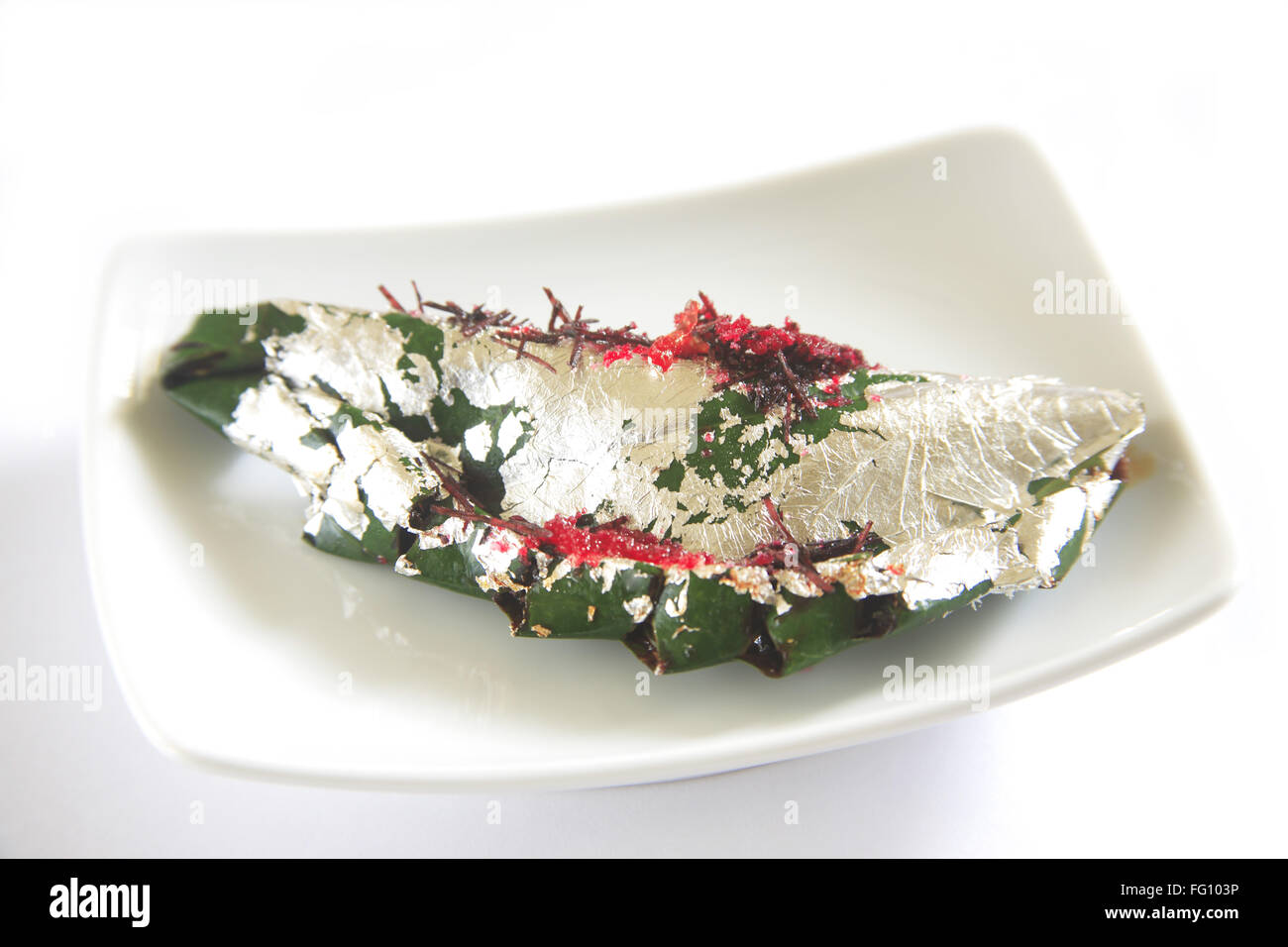 Gilouri pan prepared and folded in betel leaves serve in plate on white background Stock Photo