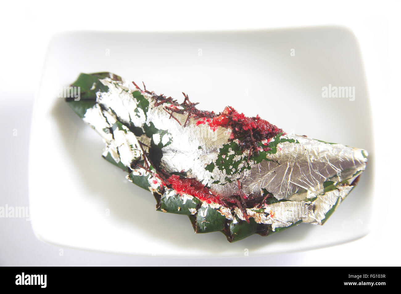 Gilouri pan prepared and folded in betel leaves serve in plate on white background Stock Photo