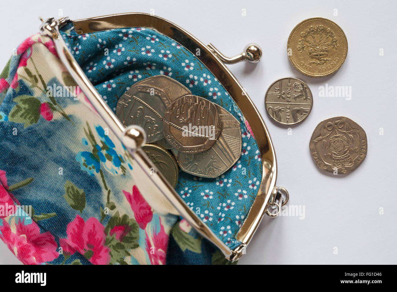 Loose change in pretty flowery purse set on white background Stock Photo