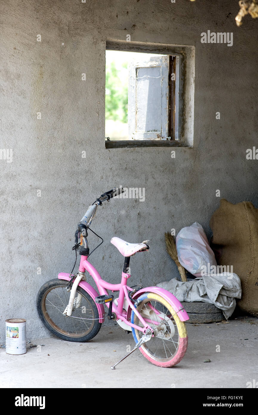 Baby bicycle stand near a window ; India Stock Photo