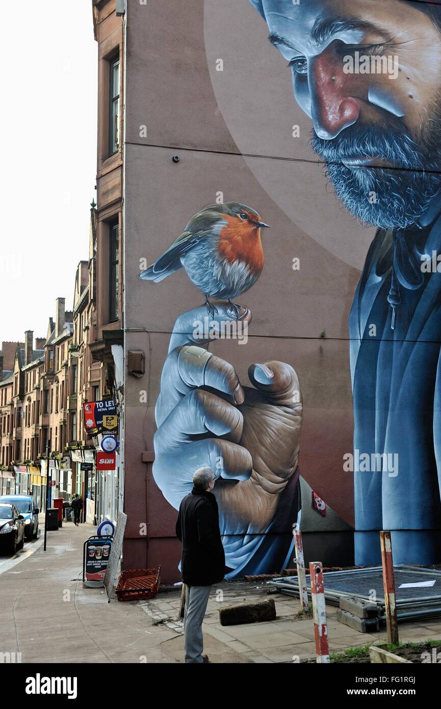Glasgow, UK. 17th Feb, 2016. A man admires the new mural by Australian street artist Smug that has emerged on High Street, Glasgow, the latest in a series of urban art to adorn the city's walls. Credit:  Tony Clerkson/Alamy Live News Stock Photo