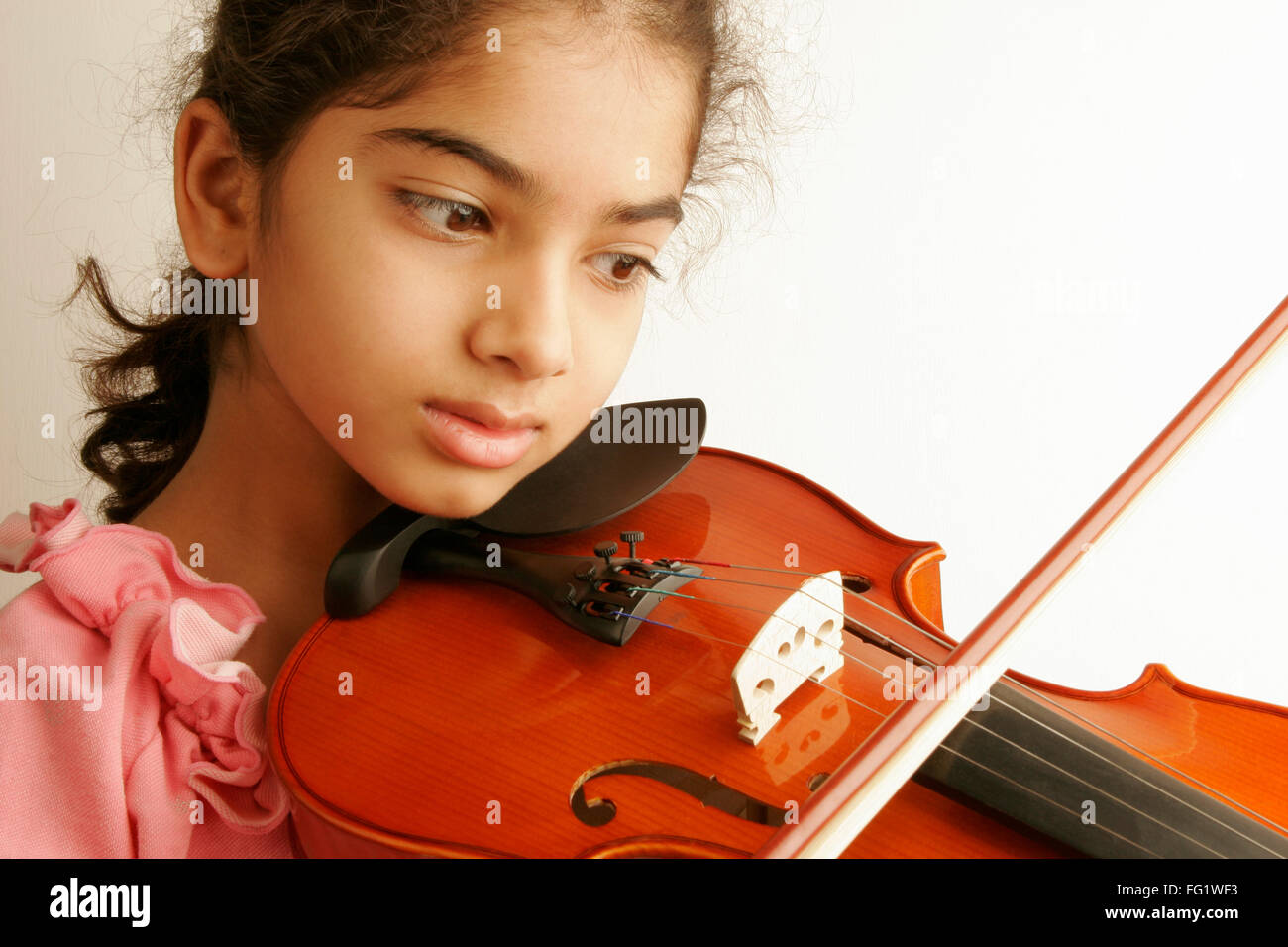 South Asian Indian ten year old girl playing Indian musical instrument