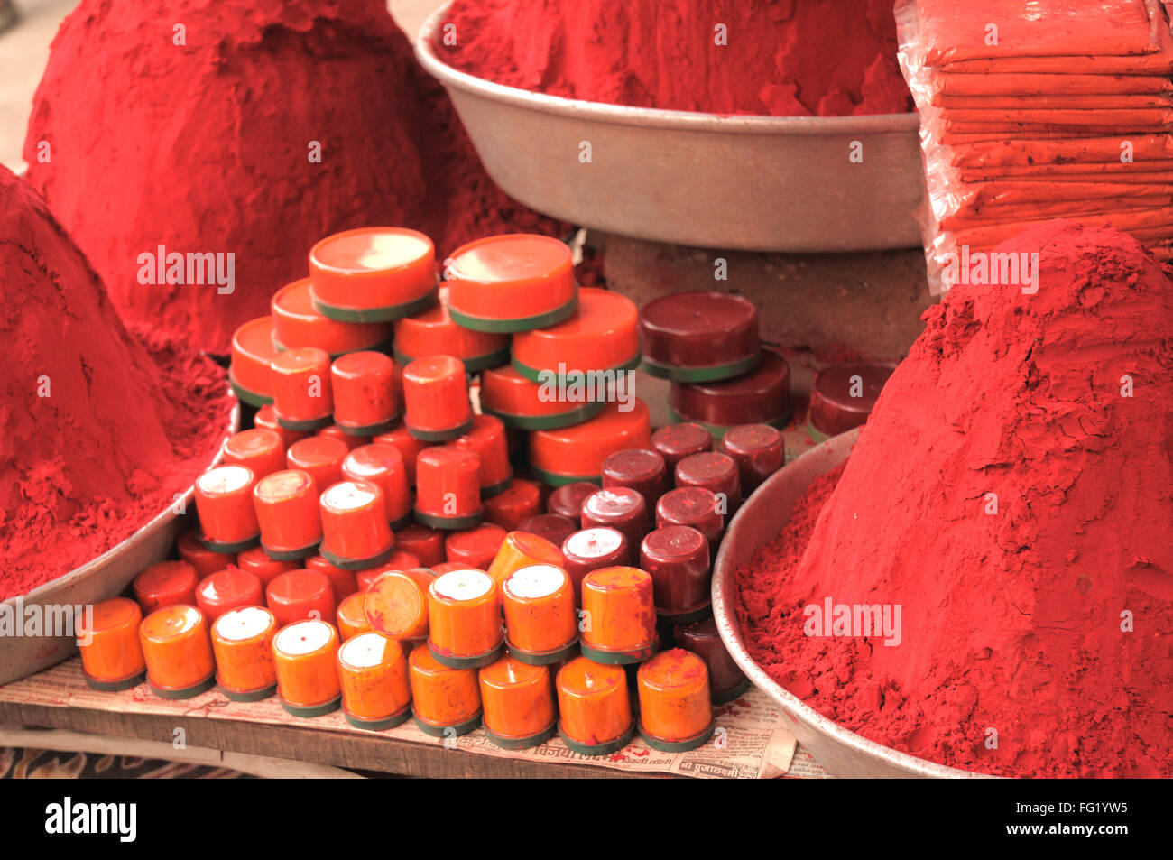 Heaps of red coloured powder kumkum with small plastic containers ; Khidrapur ; Kolhapur ; Maharashtra ; India 16 March 2008 Stock Photo