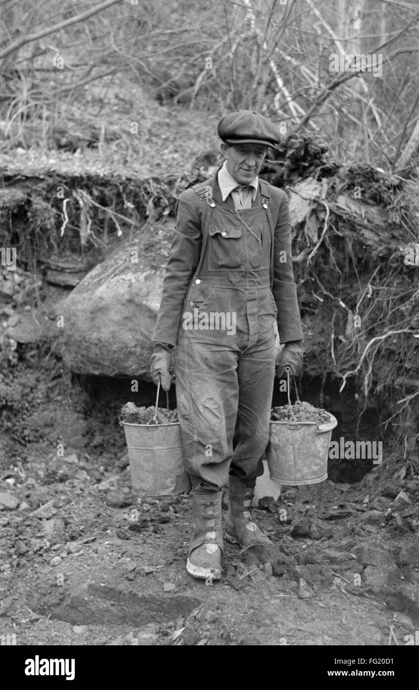 SOUTH DAKOTA MINER, 1938. /nA gold miner preparing to pan buckets of