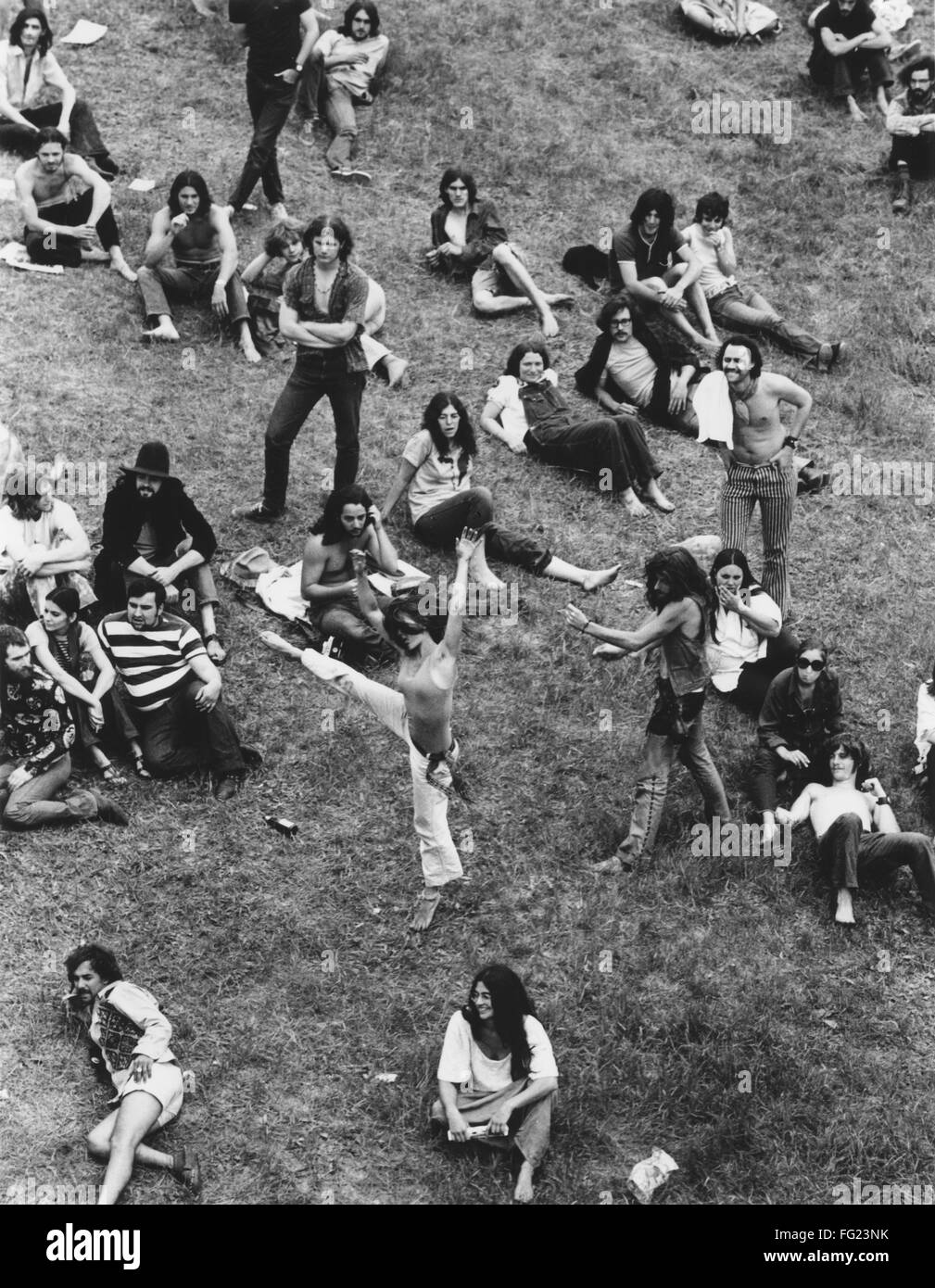 HIPPIE MOVEMENT, 1970. /nA group of hippies, two of them dancing, sits
