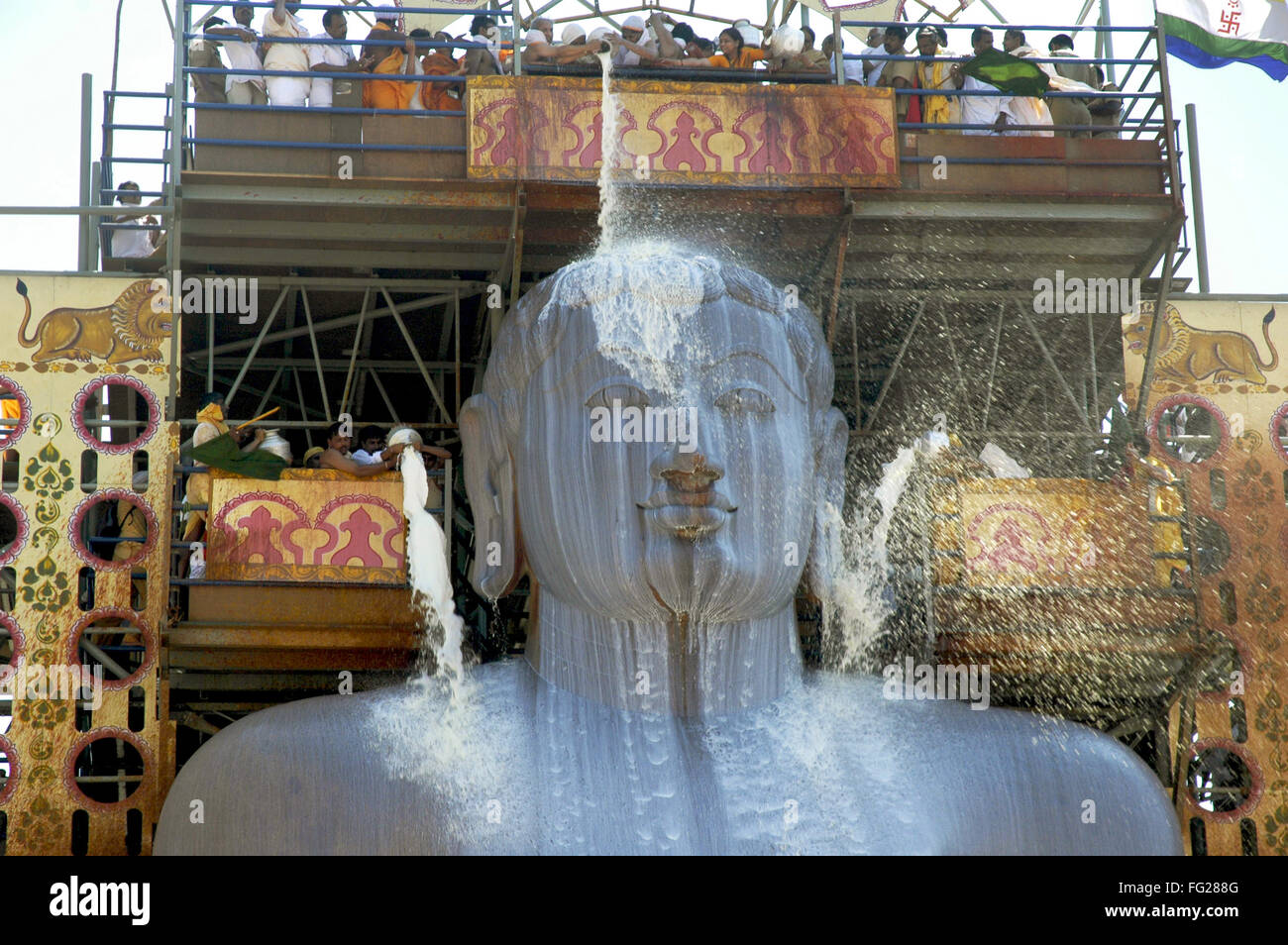 Jain Devotees pouring milk on head monolithic Statue jain saint Gomateshwara Mahamastak abhishekaShravanbelagola Karnataka Stock Photo