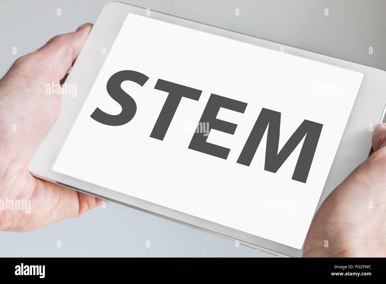 STEM (science, technology, engineering, math) concept with text being displayed on modern touch screen of a white tablet. Stock Photo