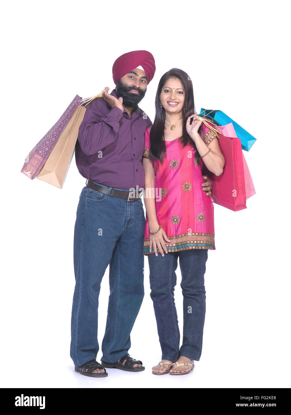 Sikh man and woman holding colourful shopping bags standing close to each other MR#702Z;779A Stock Photo