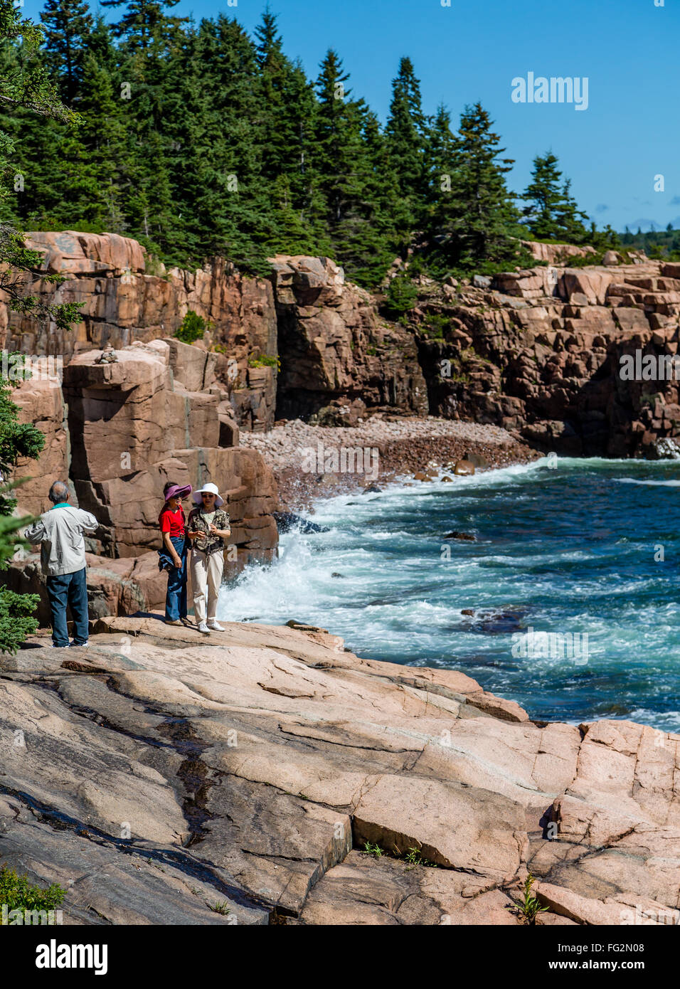 Two Asian Women on rocks in Acadia National Park near Bar Harbor, Maine Stock Photo