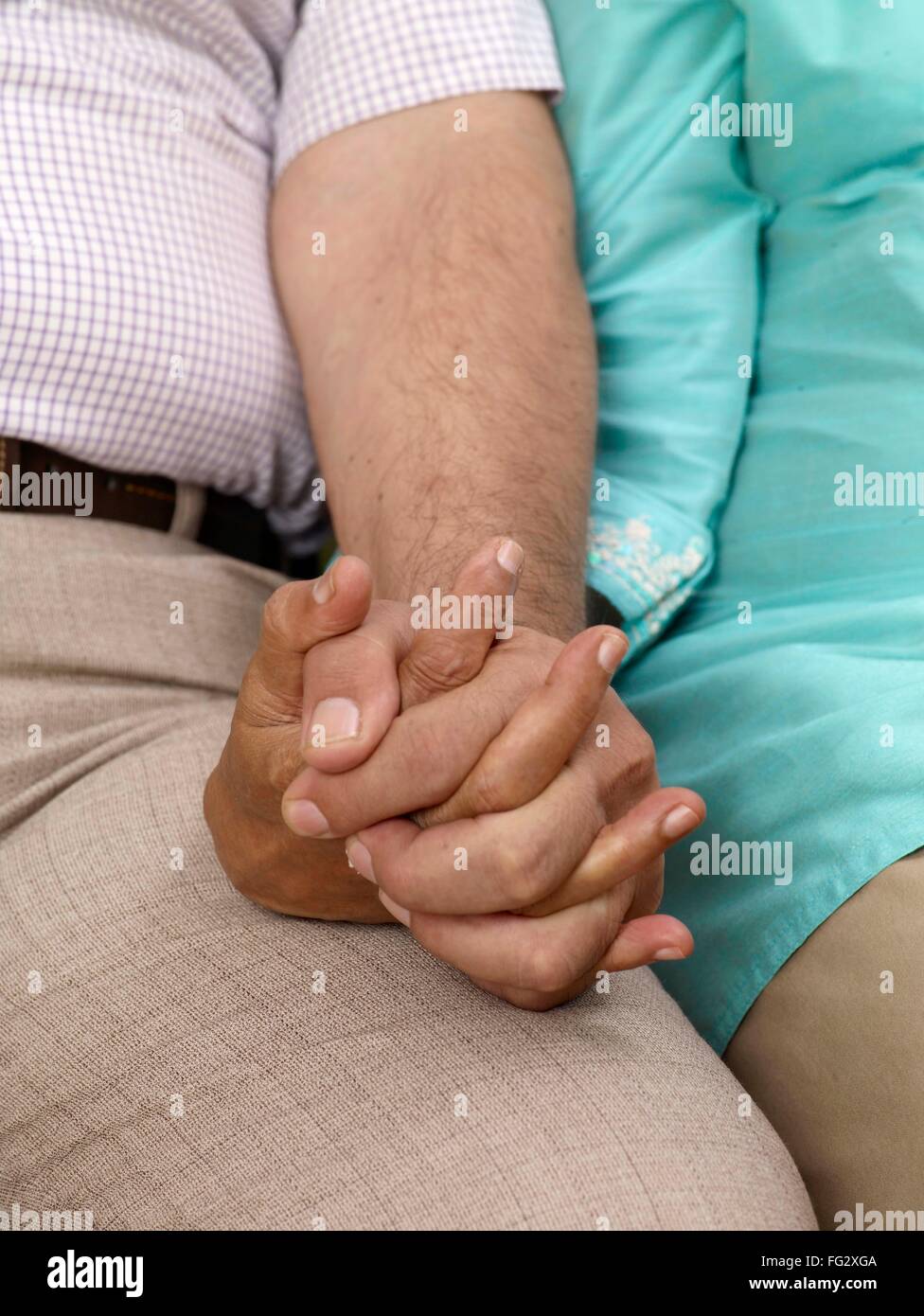 Old couple holding hands sitting close to each other MR#702T,702S Stock Photo