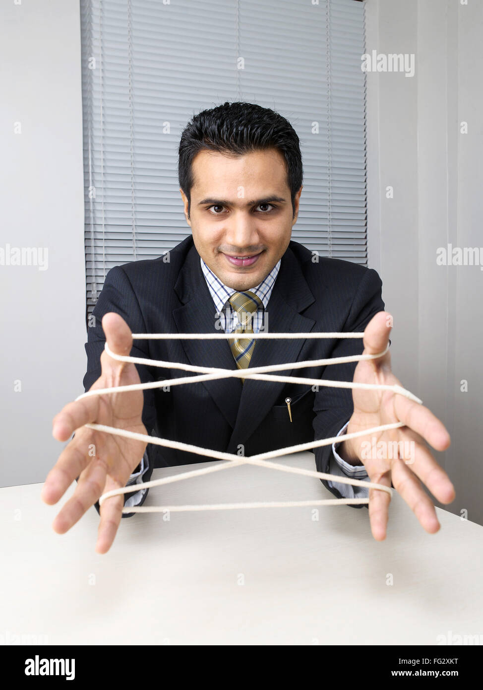 Executive making cats cradle with string MR779K Stock Photo Alamy