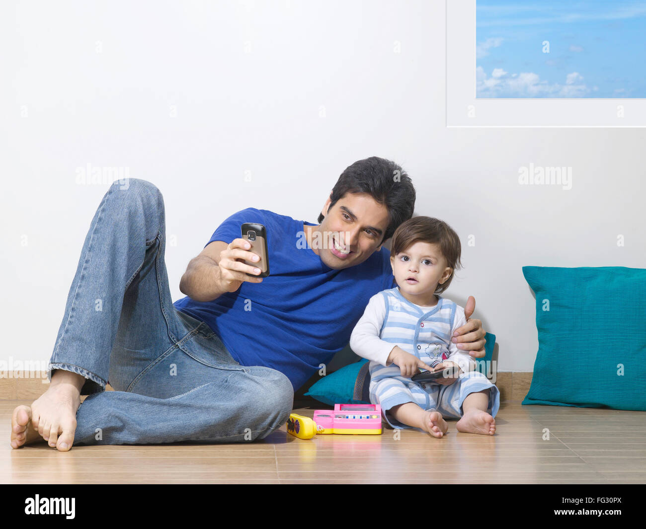 Father showing mobile phone to baby ; MR#779L ; MR#779N Stock Photo