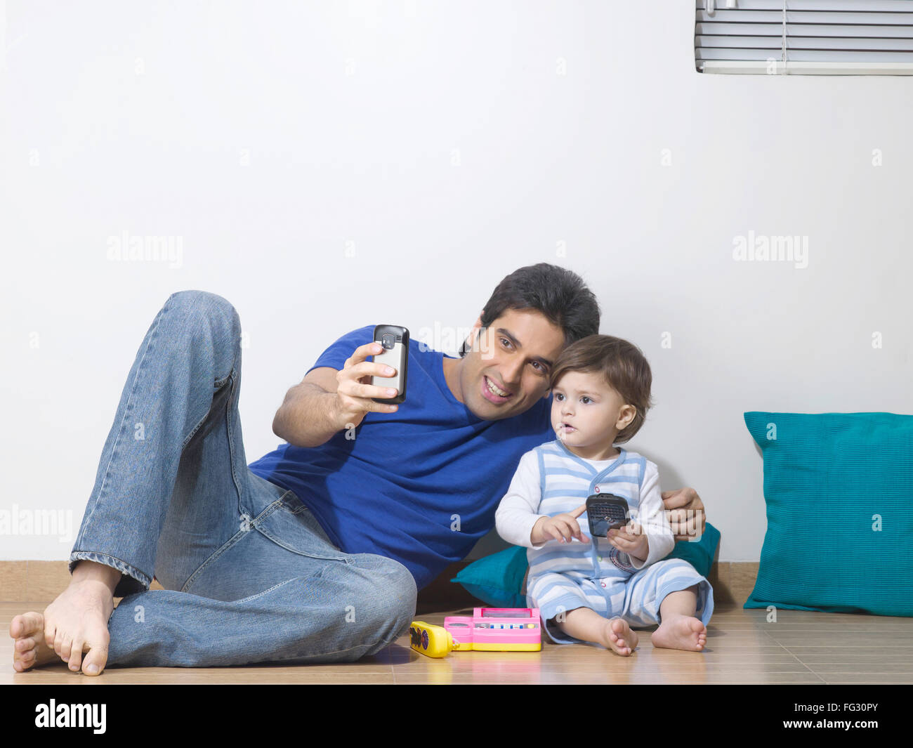 Father showing mobile phone to baby  ; MR#779L ; MR#779N Stock Photo