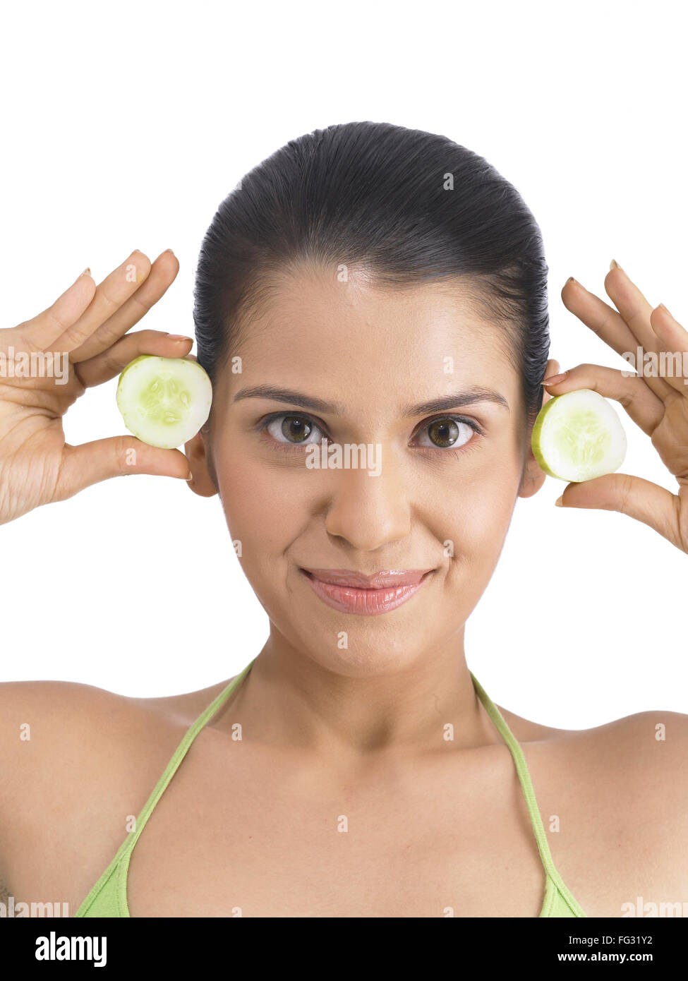 South Asian Indian woman holding and showing cucumber wearing green dress MR # 702 Stock Photo