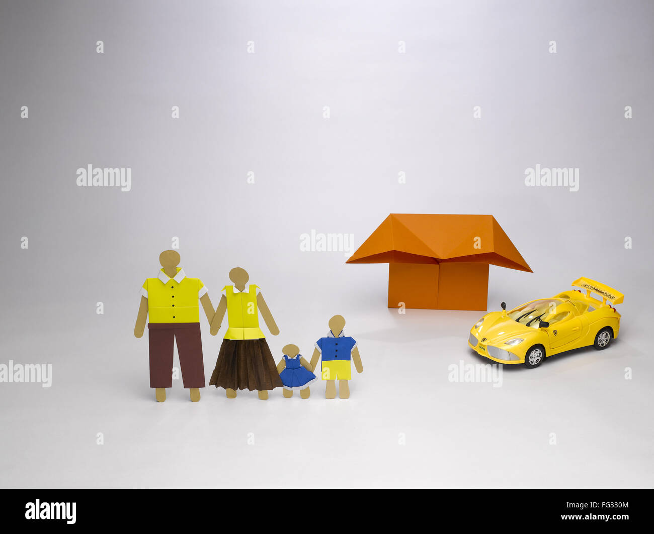 origami family icon in front of house and sport car India Asia Stock Photo