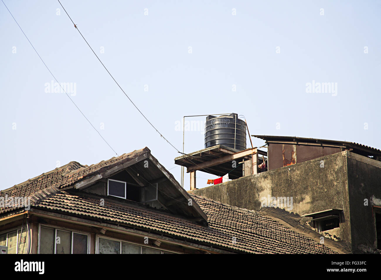 P.V.C. water tank top on chawl mud roof mass , Bombay Mumbai , Maharashtra , India Stock Photo