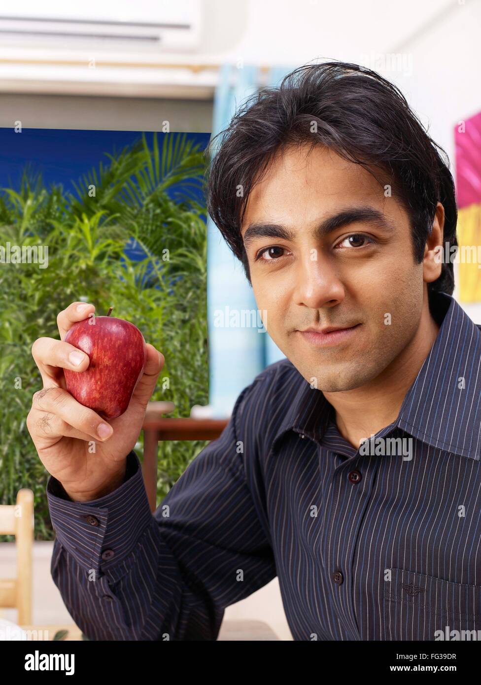 Young man showing red apple in hand MR#702V Stock Photo