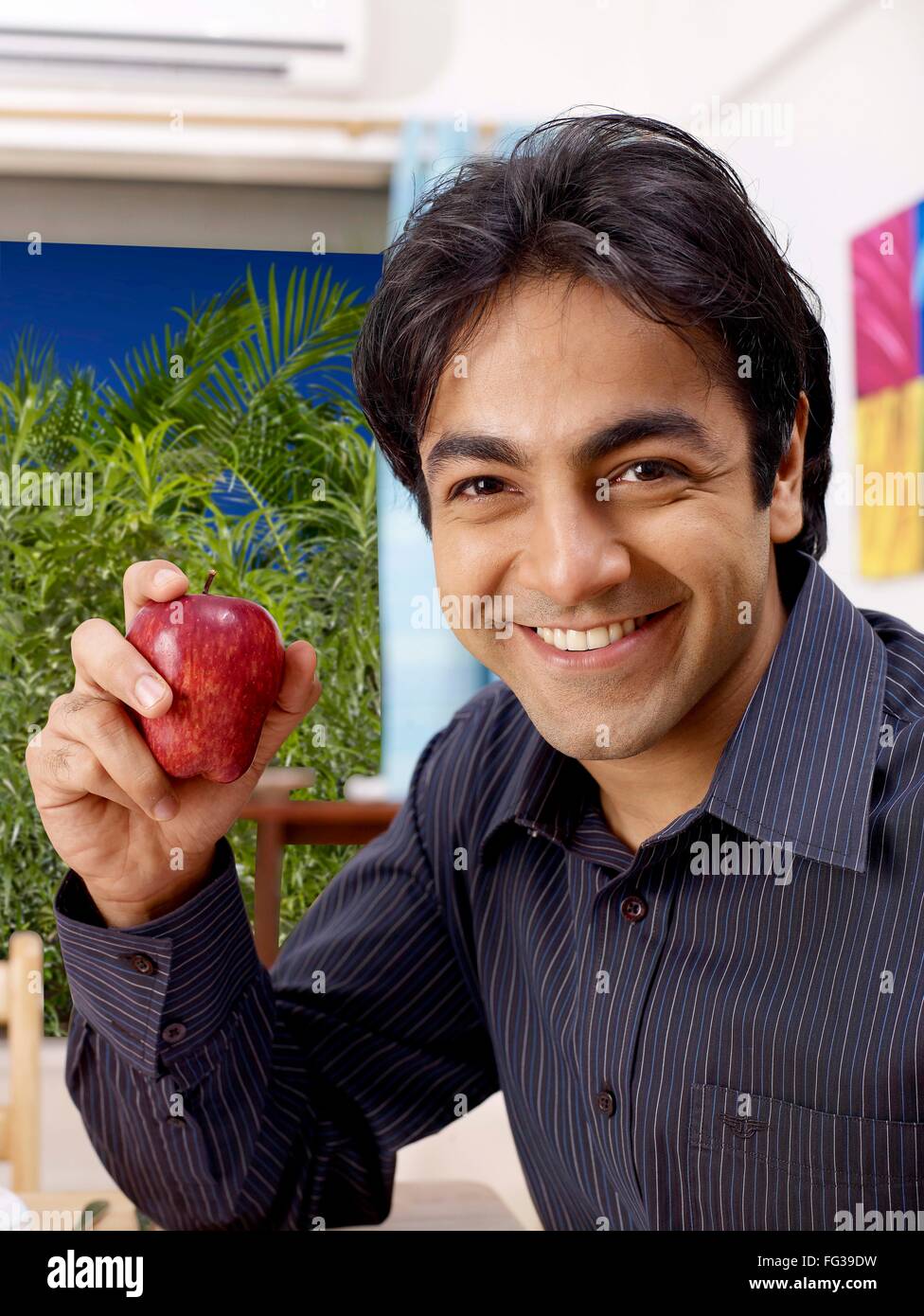 Young man showing red apple in hand MR#702V Stock Photo