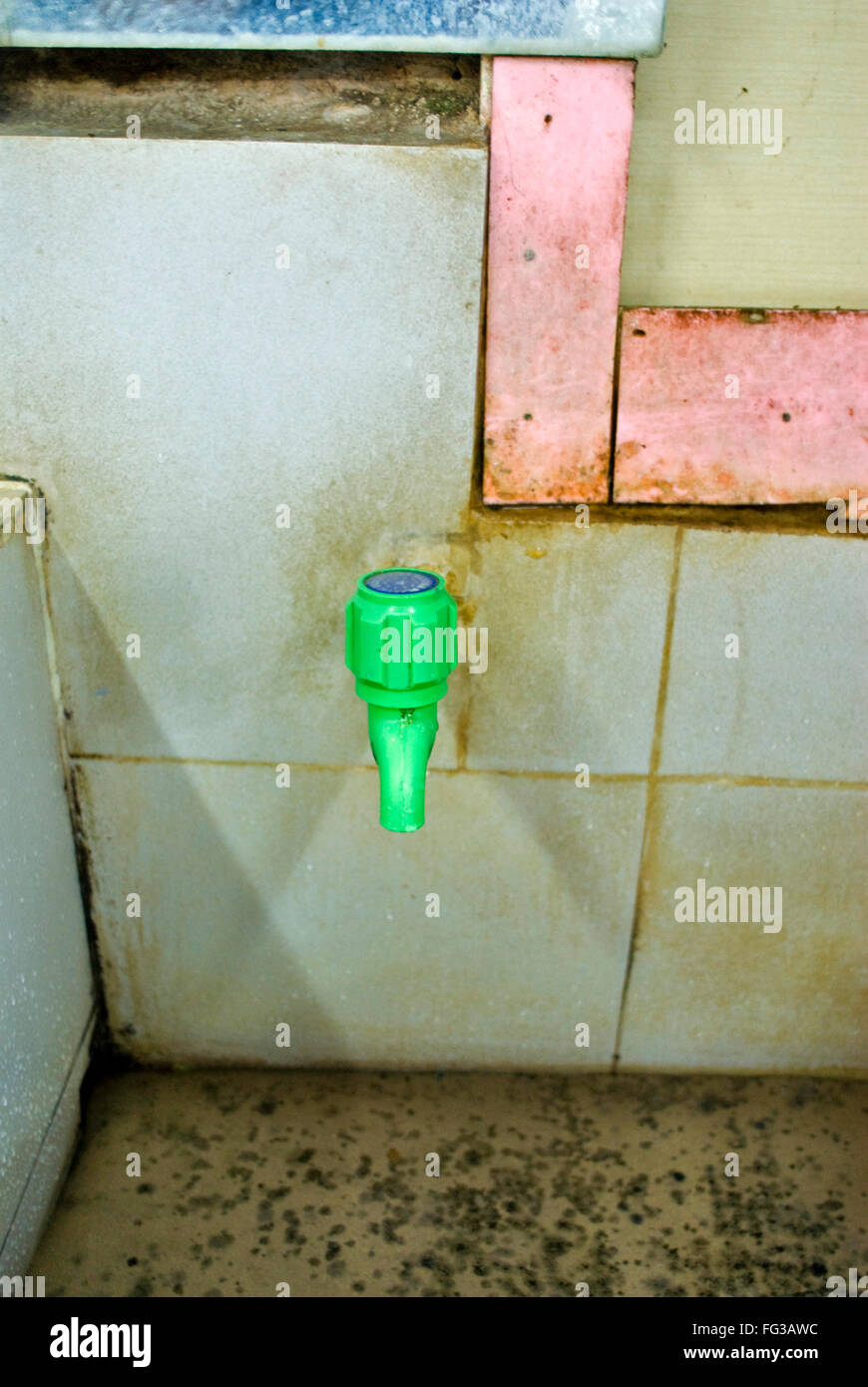 Green plastic tap in cement and tile wash basin ; Old Dhaka ; Bangladesh Stock Photo