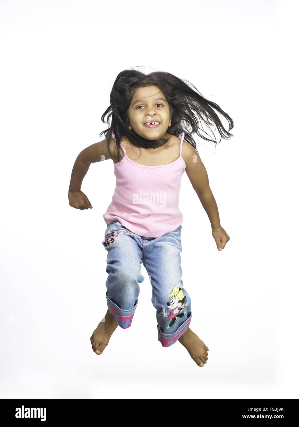 South Asian Indian girl jumping with joy in nursery school MR Stock Photo